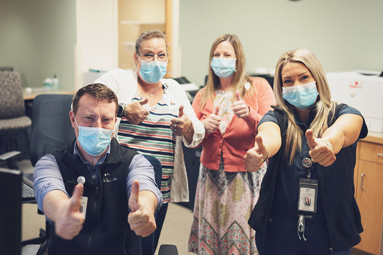 A team of cancer care specialists give a double thumbs up to the living the mission award